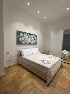 a bedroom with a bed and a painting on the wall at Lily Suite in Palermo