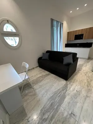 a living room with a black couch and a window at Lily Suite in Palermo
