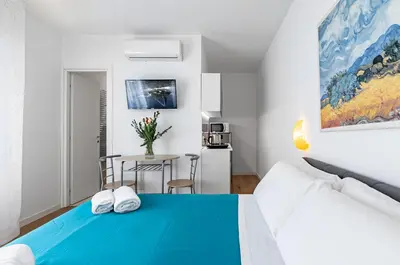 a bedroom with a blue bed and a table at GuestHost - Teatro Massimo Modern Studio in Palermo