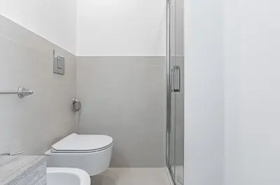 a bathroom with a toilet and a glass shower at GuestHost - Teatro Massimo Modern Studio in Palermo