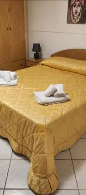 a yellow bed with towels on top of it at Milicia Apartment in Mandra Capreria