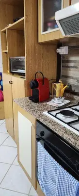 a kitchen with a stove and a red bag on the counter at Milicia Apartment in Mandra Capreria