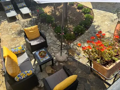 an overhead view of a patio with chairs and flowers at Le Casette di campagna #2 in Campofelice di Roccella