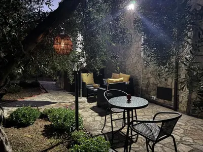 a patio with a table and chairs and a lamp at Le Casette di campagna #2 in Campofelice di Roccella