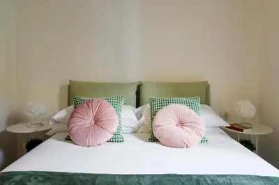 a bed with two pink pillows on it at Ermosa Suite in Palermo