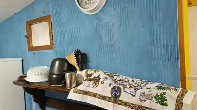 a bedroom with a blue wall and a table with a blanket at LA TERRAZZA SUL MARE monolocale con terrazza vicino aereoporto&mare SICILIAN VINTAGE STYLE BEACH HOUSE in Cinisi