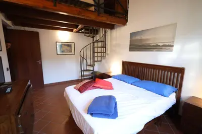 a bedroom with a bed with blue and red pillows at Politeama Holiday Home - La tua casa nel cuore di Palermo! in Palermo