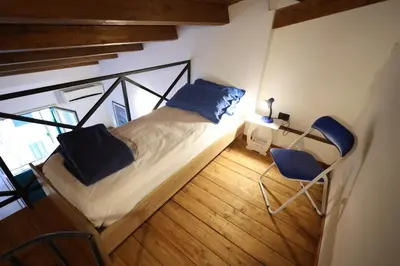 a bedroom with a bed and a desk and two chairs at Politeama Holiday Home - La tua casa nel cuore di Palermo! in Palermo