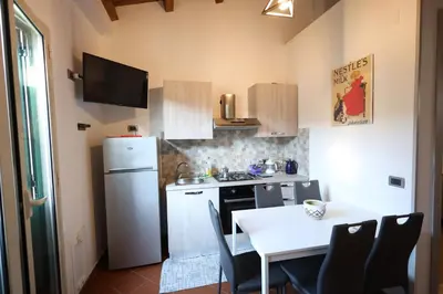 a small kitchen with a table and a white refrigerator at Politeama Holiday Home - La tua casa nel cuore di Palermo! in Palermo