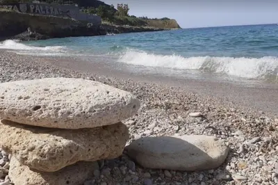 two rocks stacked on a beach near the water at Casa Gabriele in Palermo