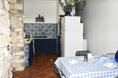 a dining room with a table with a blue and white table cloth at Villa Maruzza (Sicilia Bedda) in Carini