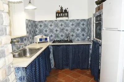 a small kitchen with a sink and a refrigerator at Villa Maruzza (Sicilia Bedda) in Carini