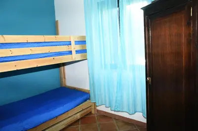 a bedroom with a bunk bed with a blue wall at Villa Maruzza (Sicilia Bedda) in Carini