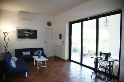 a living room with a blue couch and a table at Villa Maruzza (Sicilia Bedda) in Carini