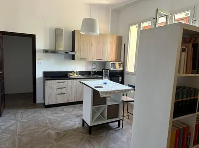a kitchen with a counter and a table in it at Casa Vacanza Mondello in Palermo