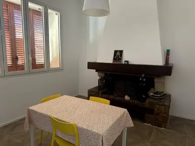 a dining room with a table and chairs and a fireplace at Casa Vacanza Mondello in Palermo