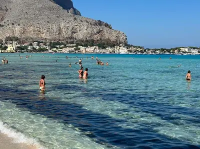 a group of people in the water at the beach at Casa Vacanza Mondello in Palermo