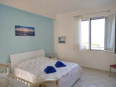 a bedroom with a bed with blue towels on it at Le finestre sul mare in Santa Flavia