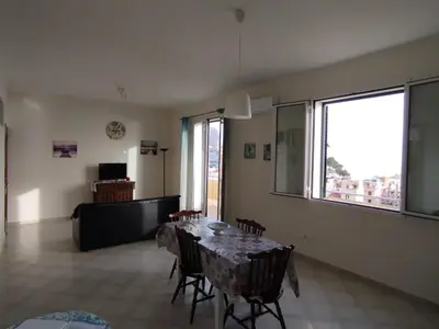 a dining room with a table and chairs and a window at Le finestre sul mare in Santa Flavia
