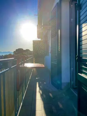 a view of a balcony of a building with the sun setting at Le finestre sul mare in Santa Flavia