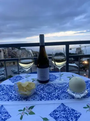 a bottle of wine and two glasses on a table at Le finestre sul mare in Santa Flavia
