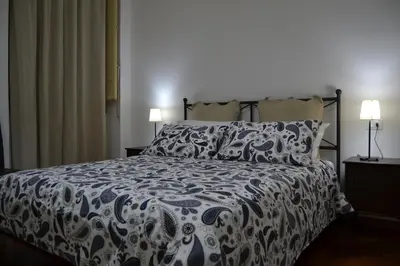 a bedroom with a bed with a blue and white comforter at B&B Paolo e Mariella in Palermo