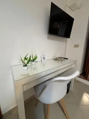 a white desk with a white chair and a television at A Due Passi da Mondello in Palermo