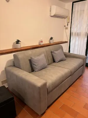 a couch in a living room with two pillows on it at A Due Passi da Mondello in Palermo