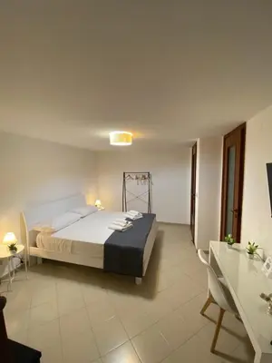 a bedroom with a large bed and a table at A Due Passi da Mondello in Palermo