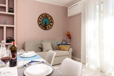 a living room with a table and a couch at I Tre Golfi - Residenza Cala Azzurra in San Vito lo Capo