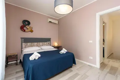 a bedroom with a bed with blue sheets and white pillows at I Tre Golfi - Residenza Cala Azzurra in San Vito lo Capo