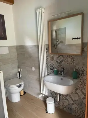 a bathroom with a sink and a toilet and a mirror at Orto Raccolto in Termini Imerese