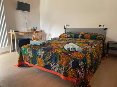 a bedroom with a bed with a colorful comforter at Orto Raccolto in Termini Imerese
