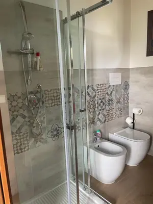 a bathroom with a shower and a toilet and a sink at Orto Raccolto in Termini Imerese