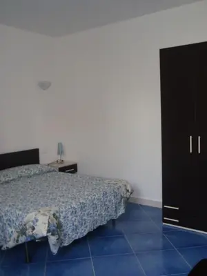 a bedroom with a bed and a black cabinet at casa cocos in San Vito lo Capo