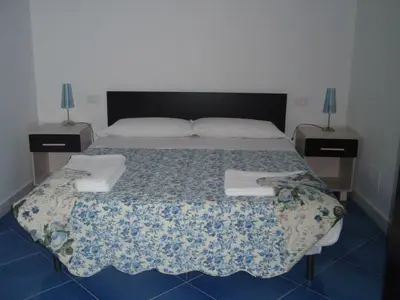 a bed in a room with two nightstands and a bed sidx sidx sidx at casa cocos in San Vito lo Capo