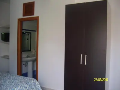 a bedroom with a black cabinet next to a sink at casa cocos in San Vito lo Capo