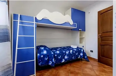 a bedroom with a bunk bed with blue cabinets at Villa Antonio in Cinisi