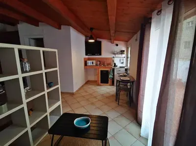 a living room with a table and a kitchen at Kappa's house in Palermo