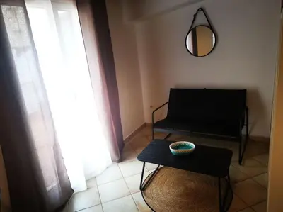 a living room with a table and a chair and a mirror at Kappa's house in Palermo