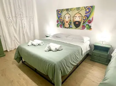 a bedroom with a bed with a painting on the wall at Da Zia Maria in Palermo