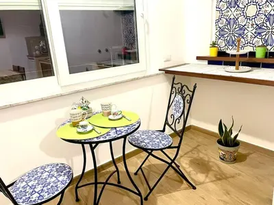 a table with two chairs and a table with cups on it at Da Zia Maria in Palermo