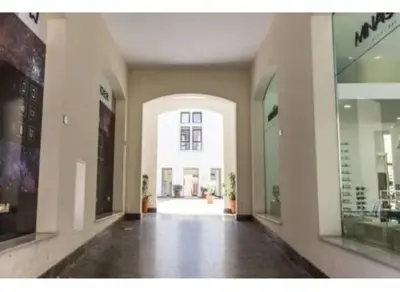 an empty hallway of a building with a large window at Shell Maqueda in Palermo