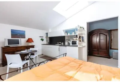 a kitchen with a bed and a kitchen with a desk at Shell Maqueda in Palermo