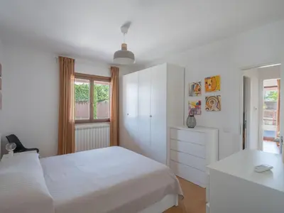 a white bedroom with a bed and a dresser at Villa Kamarà in Castellammare del Golfo