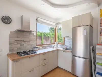 a kitchen with white cabinets and a stainless steel refrigerator at Villa Kamarà in Castellammare del Golfo