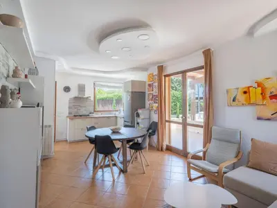 a kitchen and living room with a table and chairs at Villa Kamarà in Castellammare del Golfo