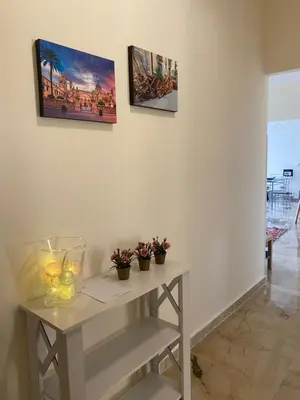 a white table with some flowers and some pictures on the wall at La Casa di Gus in Palermo