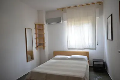 a small bedroom with a bed and a window at Casa Garofani in Carini