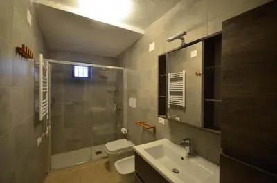 a bathroom with a shower and a toilet and a sink at Casa Garofani in Carini
